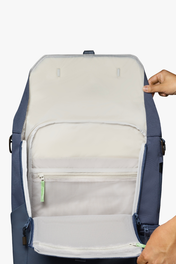 View of opened blue backpack with beige interior, showing the clamshell opening of backpack.