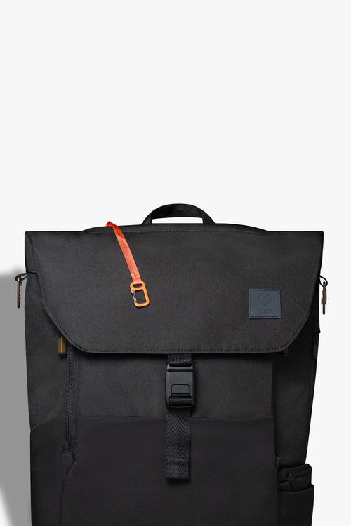 Front view of black backpack against white background. Orange key hook is hanging out from the zipper pocket on top of the backpack.