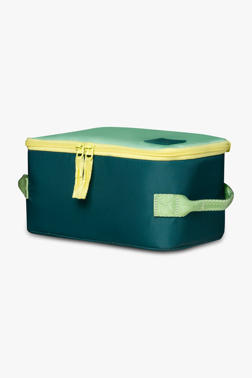 Side angle view of green insulated cooler bag with yellow zipper against a white background.