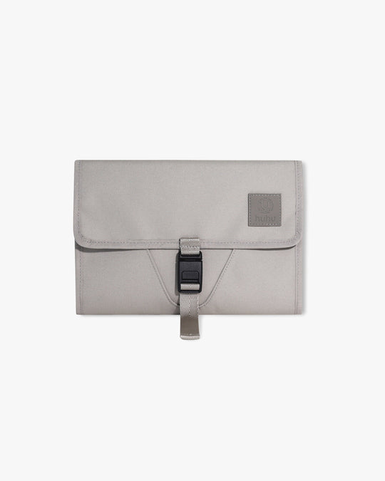 Taupe changing wallet against white background.