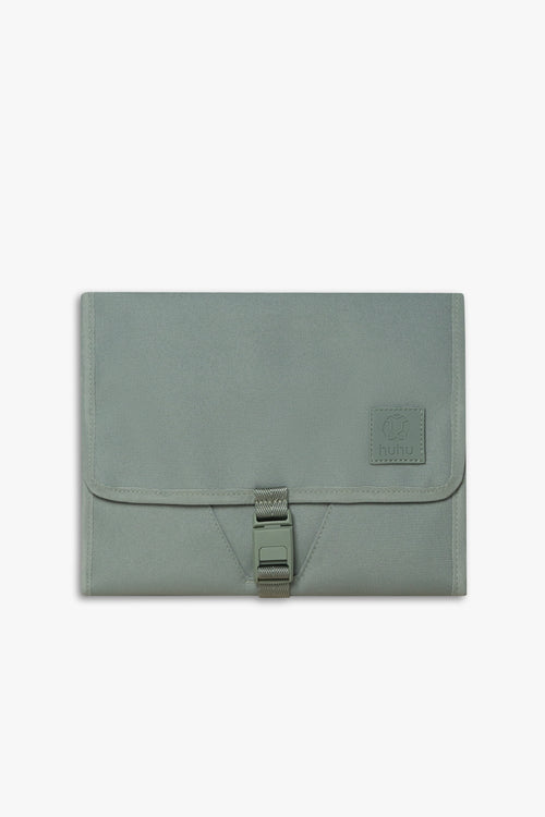 Front view of closed green changing wallet against a white background.