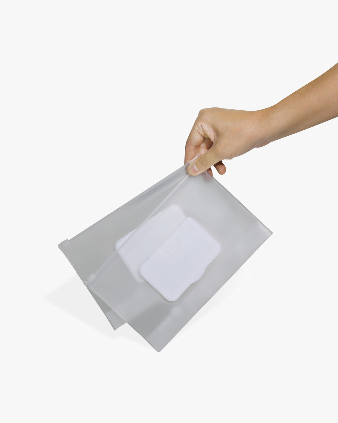 Hand holding two wipes dispensers against a white background.