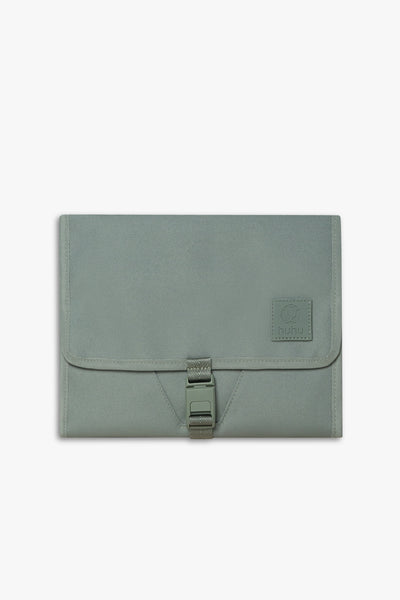 Front view of closed green changing wallet against white background.