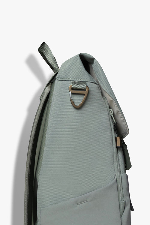Side view of green backpack showing bronze carabiner clip hook.