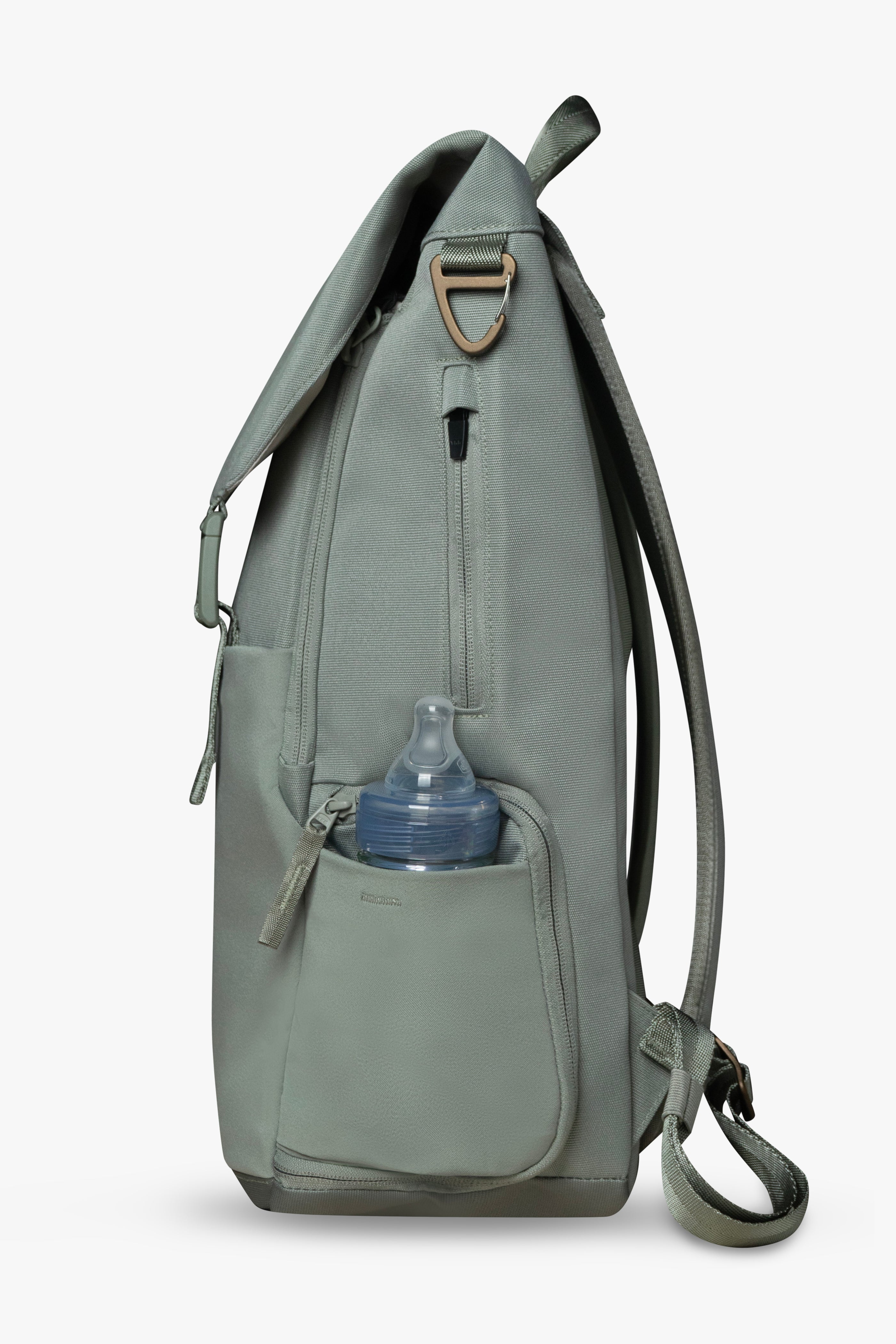 Side view of green backpack against a white background. Showing baby bottle in side stretchy bottle pocket. Bronze bag hardware and exterior zippered wipes pocket are visible.