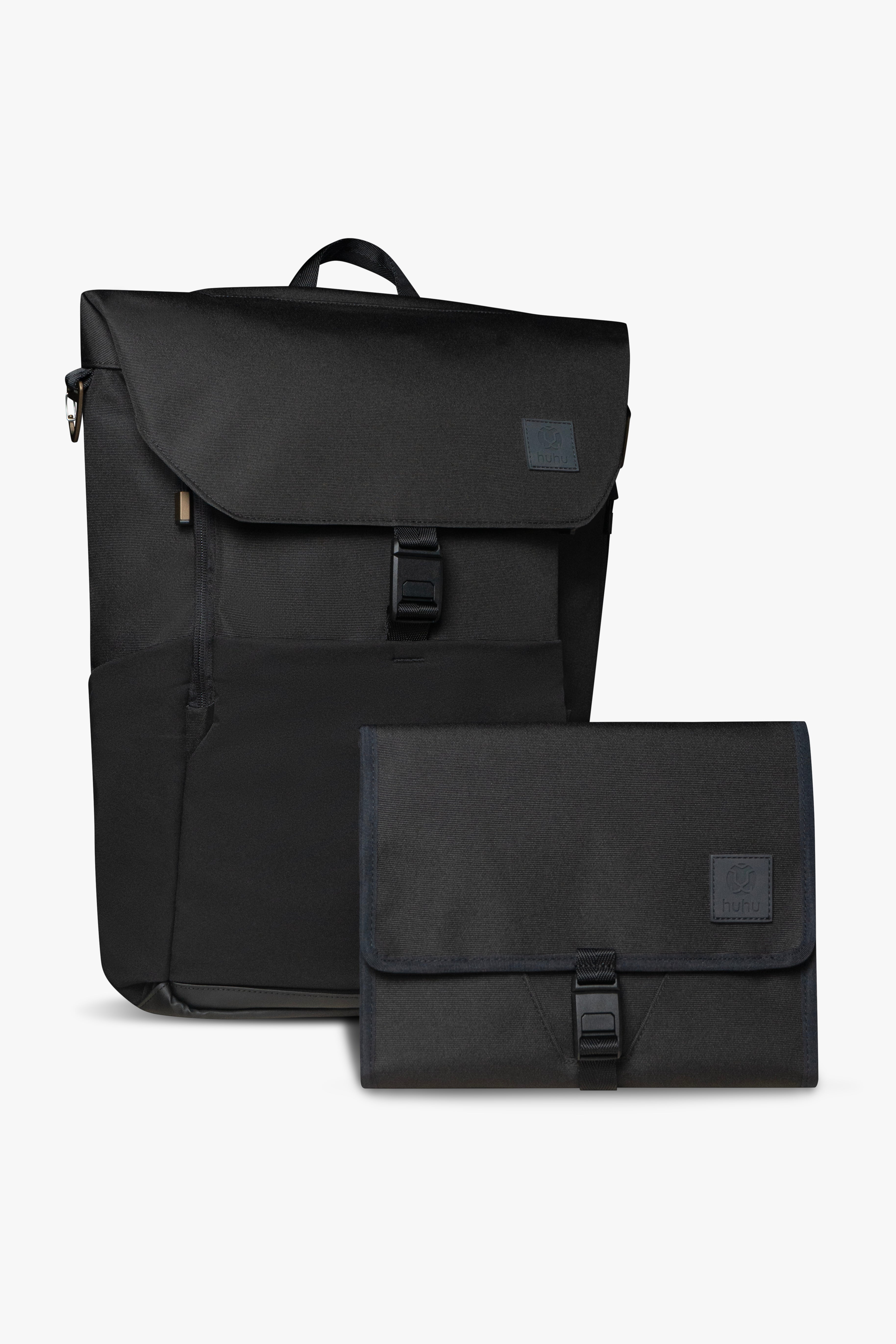 Front view of black backpack and changing wallet. Both are closed, and show magnetic clasp and exterior of products against white background.