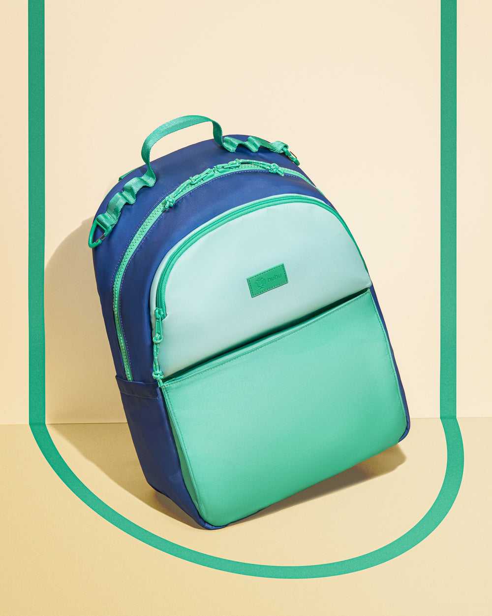 Two-tone blue and green backpack on a beige background