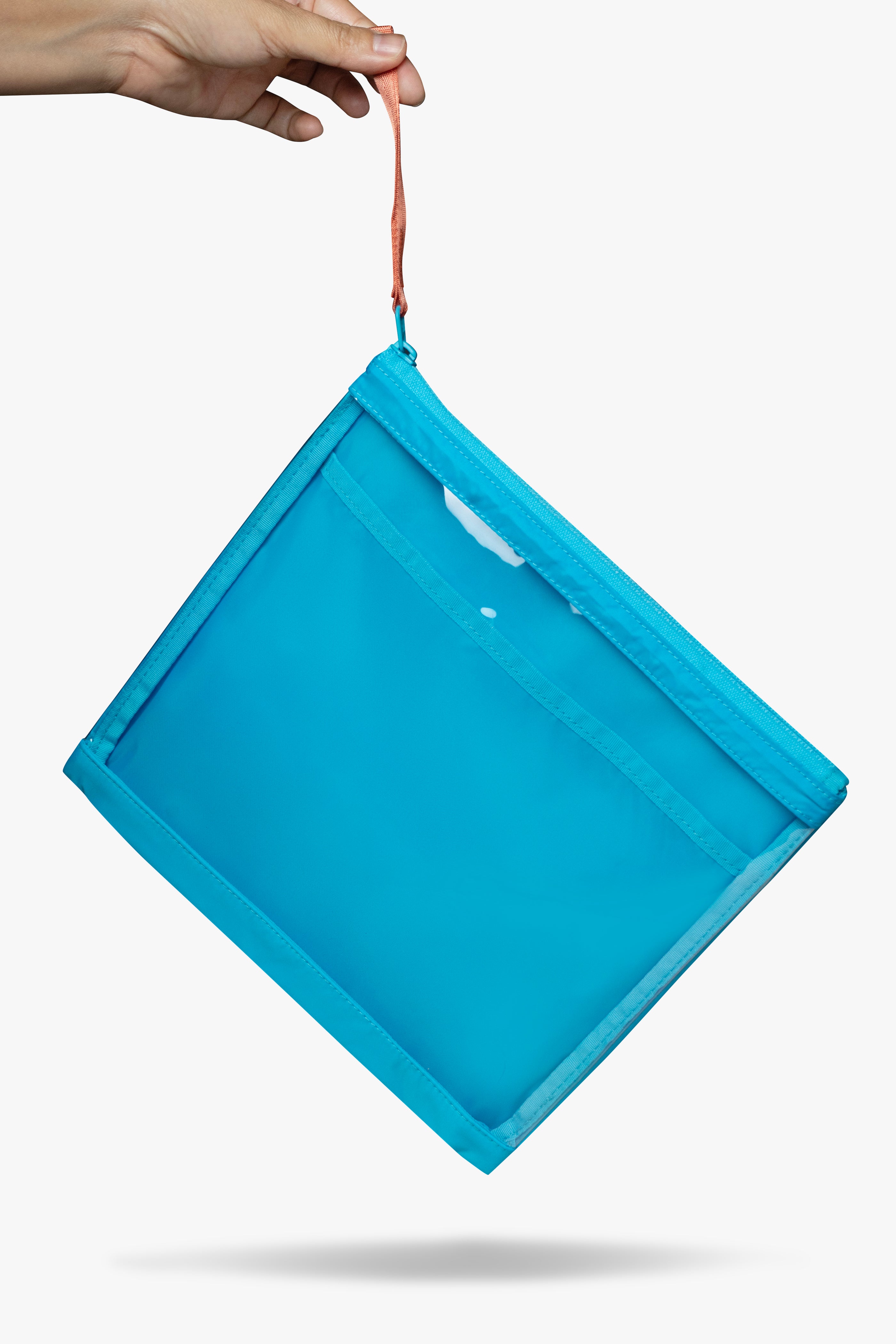 Front view of hand dangling blue changing wallet with clear front by its orange zipper pull.