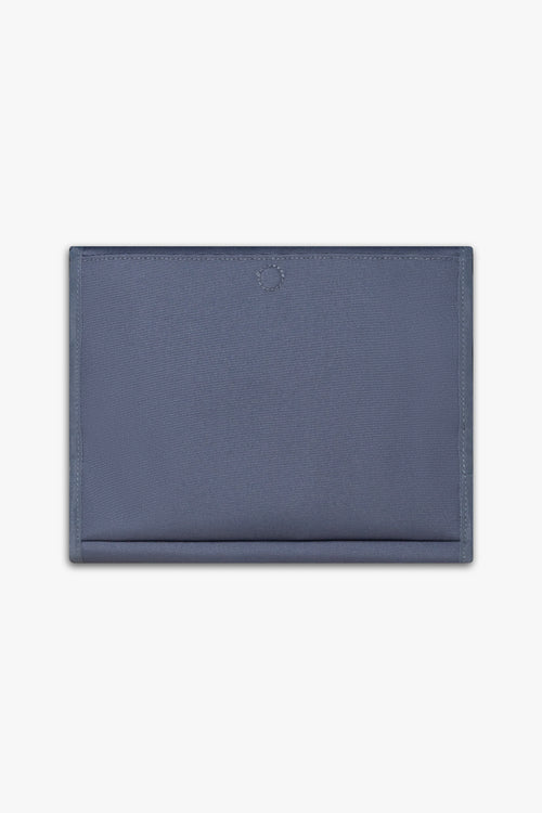 Back view of closed blue changing wallet against a white background showing back, magnetic changing pad pocket.