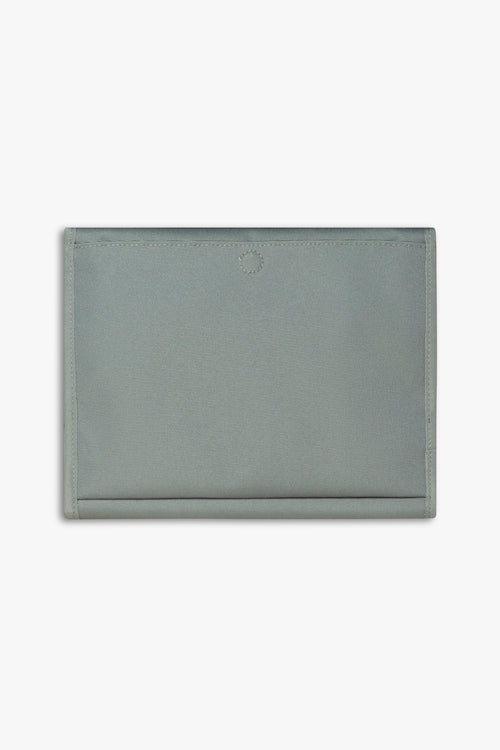 Back view of closed green changing wallet against a white background showing back, magnetic changing pad pocket.