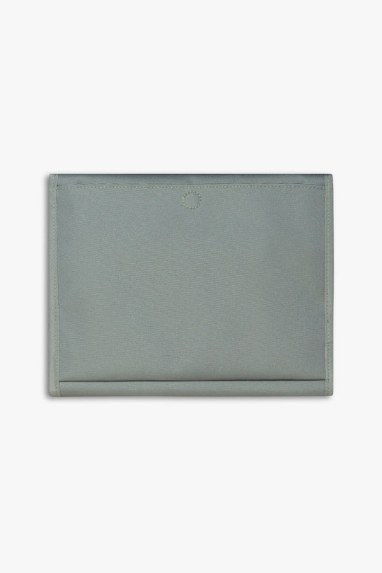 Back view of closed green changing wallet against a white background showing back, magnetic changing pad pocket.