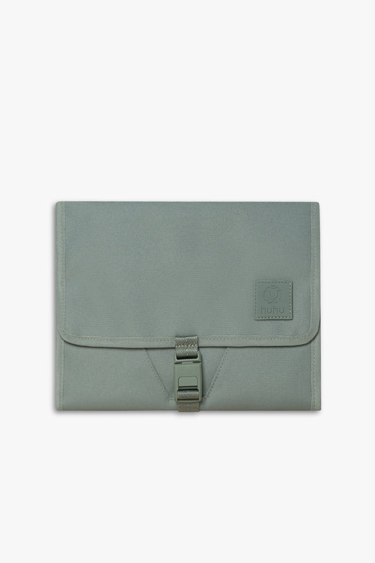 Front view of closed green changing wallet against a white background.