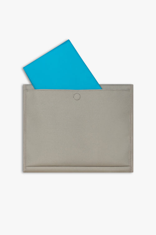 Back view of closed taupe changing wallet against a white background showing blue changing pad sitting halfway out of back pocket.