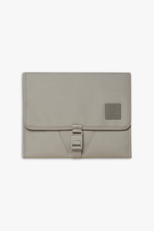 Front view of closed taupe changing wallet against a white background.